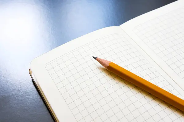 açık defter kalem siyah bir arka plan ile.