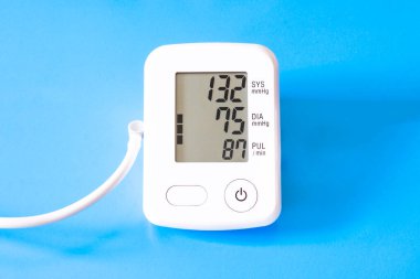 Mavi arkaplandaki tonometre. Ekrandaki okumalarla basıncı ölçmek için bir aygıt.