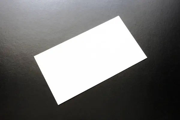 Siyah arka planda reklam için beyaz, boş bir kartvizit..