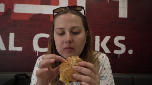 Gözlü Genç Bir Kadın Bir Fast Food Restoranında Burger Yiyor — Stok video