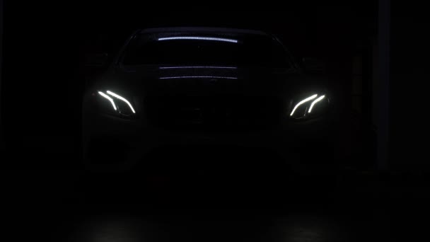 暗闇の中で 地下駐車場では 車の主なヘッドライトがオンになっています 光のハロー 車のランプのグレア — ストック動画