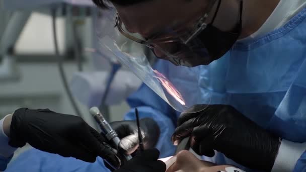 近视医生牙医在工作时小心地在面罩面罩后面戴着防护医用眼镜 — 图库视频影像