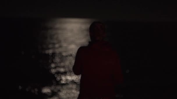 Yansıması Suyun Üzerindeki Işığıyla Gece Okyanusu Yalnızlık Kapüşonlu Bir Kız — Stok video