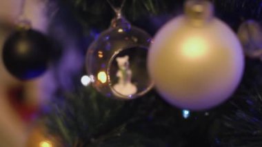 Topun içinde bir Noel ağacı oyuncağı kutup ayısının yakın plan çekimi, arka planda bir çelenge odaklan, beyaz ve siyah toplar sallanıyor