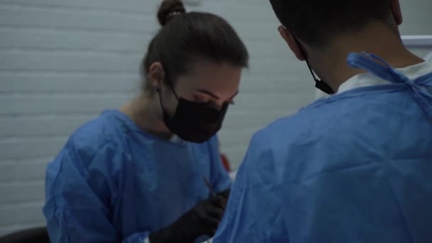 ザポリジジア ウクライナ 2021年7月08 スローモーション 医師の手術スーツ 黒手袋 マスクは手術口 看護師 アシスタント歯科オフィスを行います 針ホルダー — ストック動画