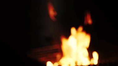Barbekü ızgarası gece vakti kamp ateşinde yanar. Güzel alevler, kıvılcımlar, duman. Sahilin arka planında, denizde, ay yolu bulanık, bokeh. El kamerasıyla ateş edilmiş. Yaz