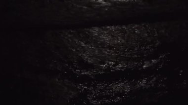 Geceleri denizde büyük dalgalar. Karanlık sularda ay ışığının yansıması. Yukarıdan bak. El kamerasıyla ateş edilmiş. Ay ışığı