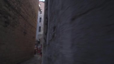 Kamera genç bir turisti takip ediyor, sarışın, güneş gözlüğü takan, pembe bir sırt çantası ve şortu, eski kasabanın dar caddelerini ve kafelerini keşfedip etrafa bakıyor. İyi günler. Yaz