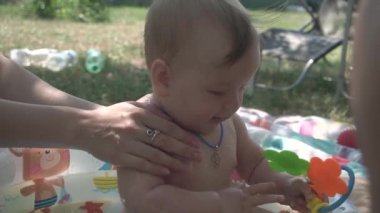 Tatlı bebek yazın havuzda oynuyor, arka bahçede, yakın plan, açık mavi gözler.