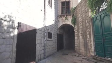 Kamera genç bir turisti takip ediyor, sarışın, güneş gözlüğü takan, pembe bir sırt çantası ve şortu, eski kasabanın dar caddelerini ve kafelerini keşfedip etrafa bakıyor. İyi günler. Yaz
