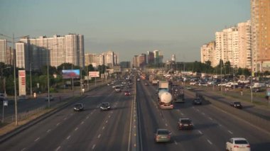 Sekiz şeritli asfalt yol arabaları, kamyonlar, otobüsler. Şehir trafiği yoğun, yoğun trafik sıkışıklığı yerleşim bölgesinde. Kyiv. Ukrayna. Otoparklar, dükkanlar, benzin istasyonları, yüksek binalar