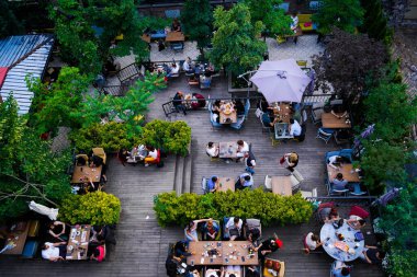 İnsanlar restoranın bahçesinde yemek yiyor.