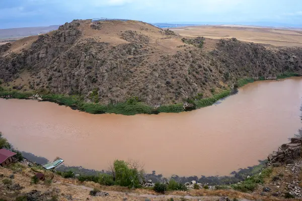 Nehir yağmurdan bulanık, kanyondan akıyor.