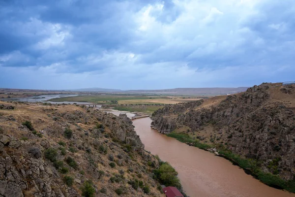 Nehir yağmurdan bulanık, kanyondan akıyor.