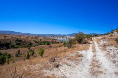 Arka planda mavi gökyüzü olan dağlarda yol.