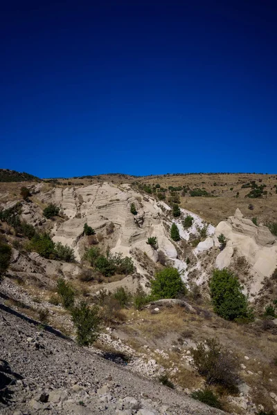 Dağlarda beyaz bir kayanın olduğu güzel bir manzara.