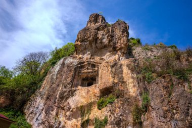 Güneşli bir günde, dağların ortasında bir şelalenin güzel bir görüntüsü.