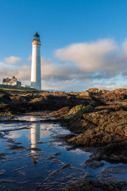 Lighthouse on the coast of the North Sea in Scotland against a dramatic sky