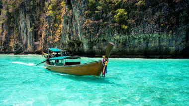 Turkuaz suda giden bir tekne. Tayland 'daki Phi Phi Adası.