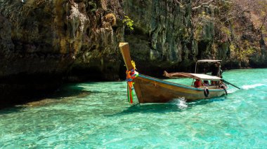 Turkuaz suda giden bir tekne. Tayland 'daki Phi Phi Adası.