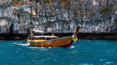 Turkuaz suda giden bir tekne. Tayland 'daki Phi Phi Adası.