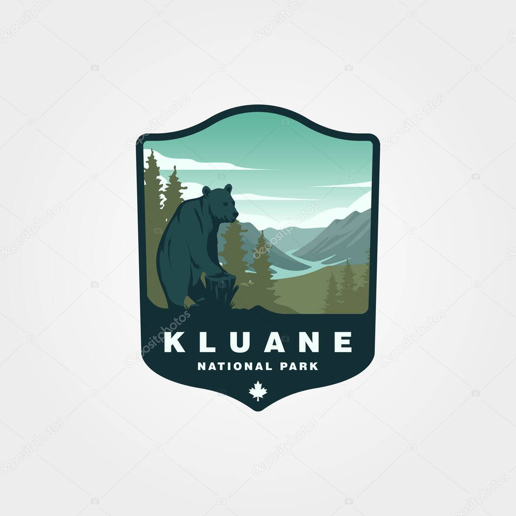 Wild bear standing in front of kluane national park and reserve vintage logo vector design