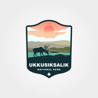 Ren geyikleri Ukkusiksalik Ulusal Parkı 'nda batan güneşin altında içerler. Doğa ve vahşi yaşam temalı tasarımlar, seyahat broşürleri ve daha fazlası için uygundur..