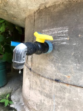 Beton bir duvara bağlı su musluğu yavaşça dışarıya damlıyor..