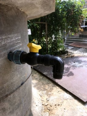 Dışarıdaki beton duvara işlevsel bir musluk monte edilmiş..