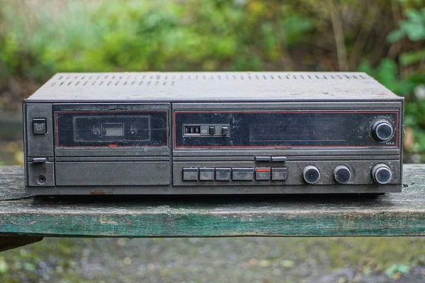 在街上的一张木制桌子上 有一台旧的大的固定式录音机 背靠着绿色的背景 — 图库照片