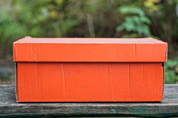 一只红色的大纸盒矗立在灰色的木制桌子上 — 图库照片