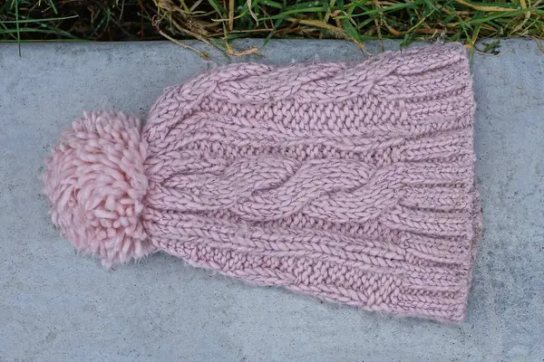 Ένα Ροζ Χειμωνιάτικο Μάλλινο Καπέλο Ένα Αφράτο Πομπόν Ξαπλώνει Ένα — Φωτογραφία Αρχείου