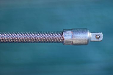 1. Bölüm: Yeşil arkaplandaki bir tornavida için gri uzun metal kablo eklentisi