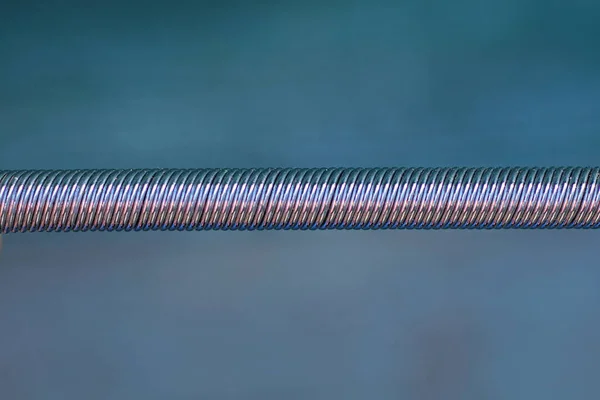 part one of a white metal spring on a green background