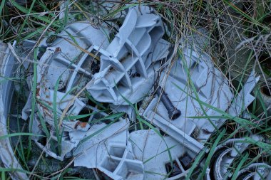 Sokaktaki yeşil çimenlikteki gri plastik parçalarından bir çöp yığını dokusu