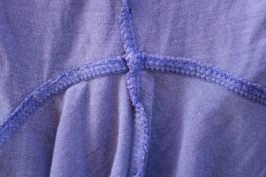 Elbiselerinde dikiş olan bir yün parçasından menekşe kumaş dokusu.