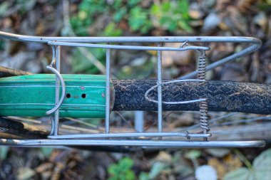 Eski bir bisikletin parçası. Gri demir bir sandıktan. Sokakta bir tekerleğin üstünden.