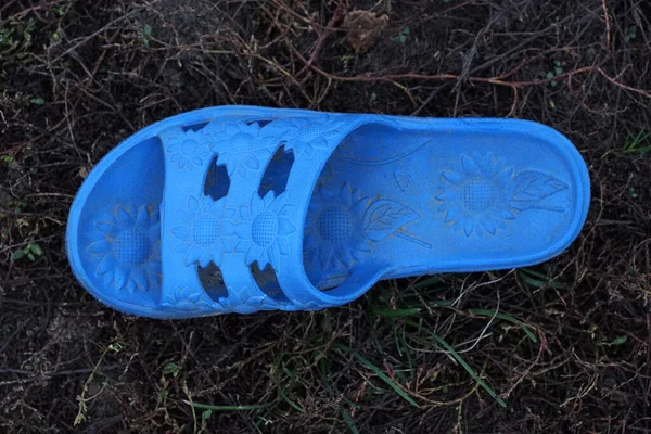 Una Zapatilla Plástico Azul Encuentra Suelo Gris Hierba Calle —  Fotos de Stock