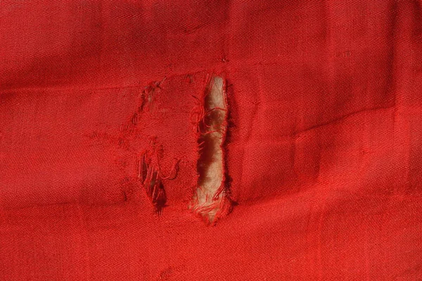 Текстура Тканини Шматка Червоного Язаного Одягу Сірою Розірваною Дірою — стокове фото
