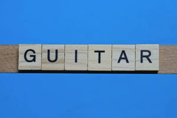Wortgitarre Aus Grauen Holzbuchstaben Liegt Auf Blauem Hintergrund — Stockfoto
