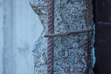 Birinci bölüm. Kırık beton sütun. Paslı kahverengi destek çubukları var.