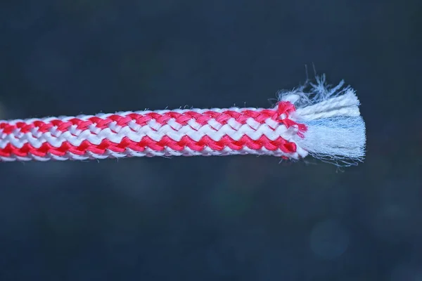 灰色の背景に白い赤いロープのコードの一部 — ストック写真