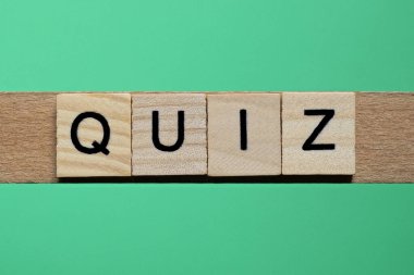 Kelime sınavı yeşil kağıtta küçük gri ahşap harflerden yapılır.