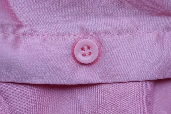 Kawałek Odzieży Różowej Jedwabnej Tkaniny Jeden Mały Plastikowy Guzik — Zdjęcie stockowe