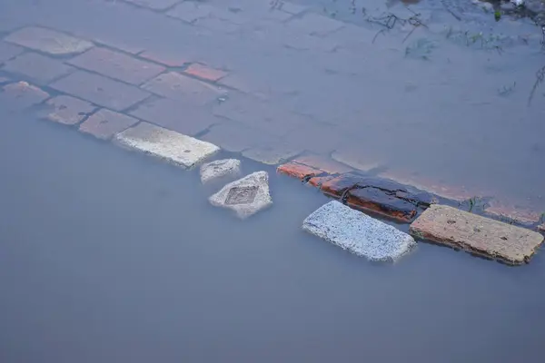 Eine Reihe Alter Brauner Nasser Ziegel Grauen Schmutzigen Wasserpfützen Auf — Stockfoto