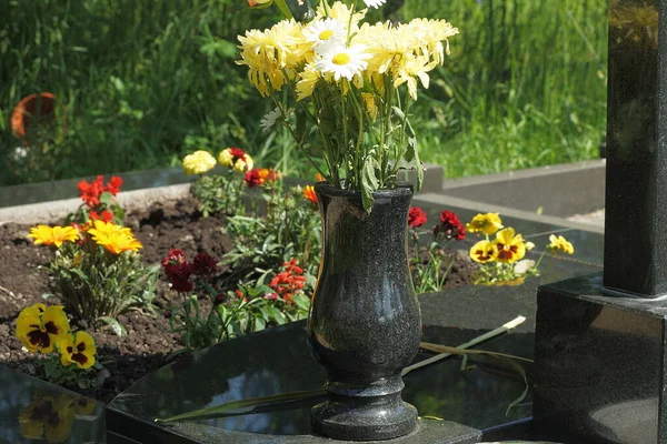 Eine Schwarze Marmorvase Mit Gelb Weißen Blumen Steht Denkmal Auf — Stockfoto