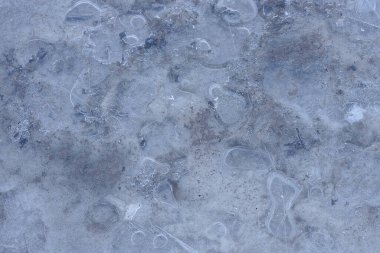 Donmuş bir kış gölünde baloncuklu buzdan yapılmış doğal gri beyaz doku.