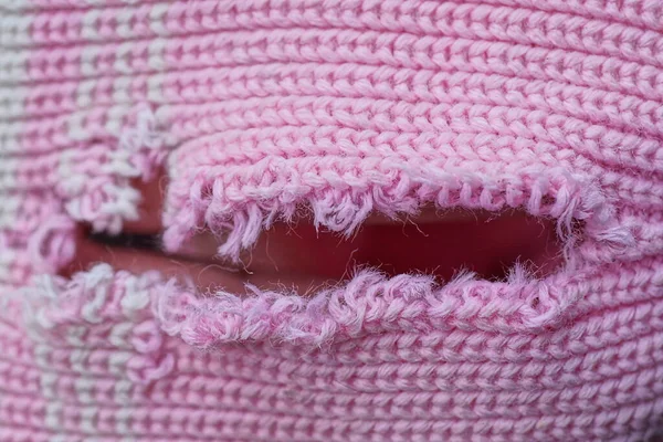 破れたWpplニットの服のピンクの白い生地の質感と穴 — ストック写真
