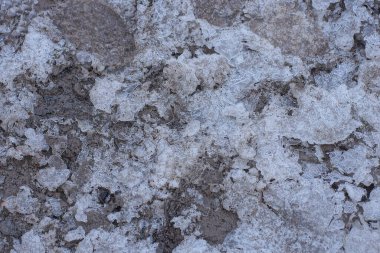 Kışlık bir sokakta yerdeki kirli kardan kaynaklanan gri beyaz doğal doku.