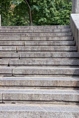 decorative concrete staircase with steps near stone gray pavement in summer park